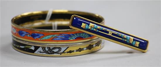 Two Hermes of Paris, gilt metal and enamel bangles (both made in Austria) and a Hermes of Paris enamelled brooch.